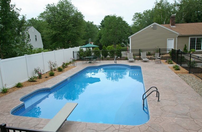 This is a photo of a patrician in ground pool with custom diving board and chairs.